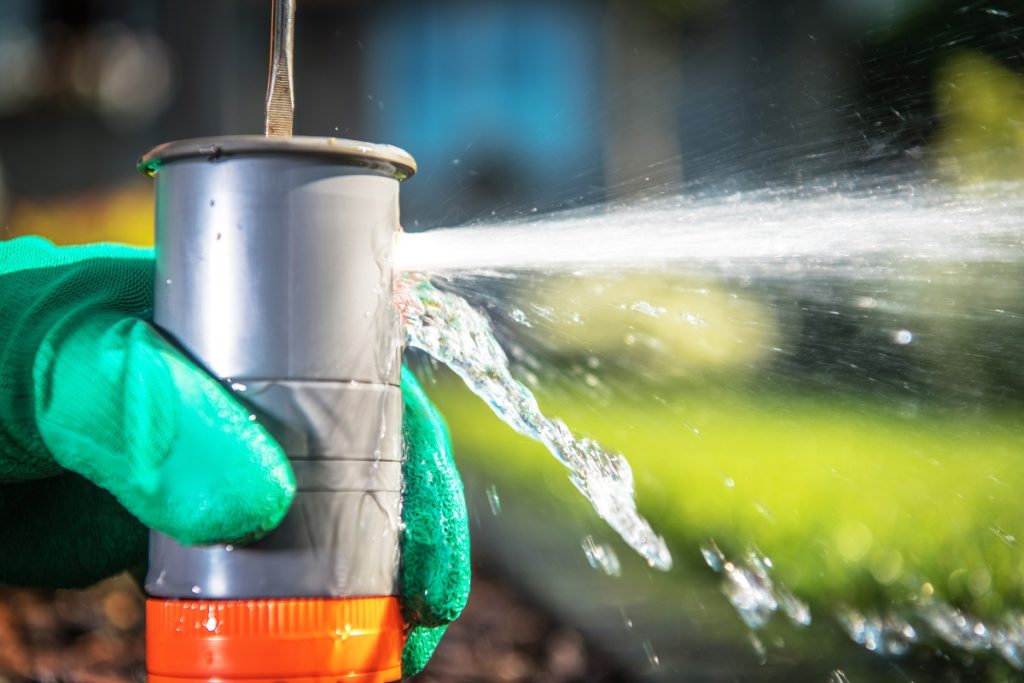 technician cleaning sprinkler head